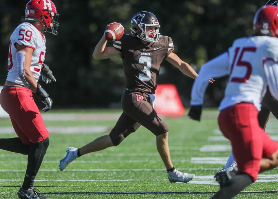 Brown University quarterback Jake Willcox throws while on the run during Saturday's game against Harvard. Willcox completed 31-of-55 passing for 284 yards and three scores.