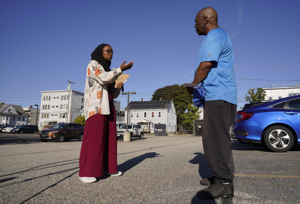 Mana Abdi, a Democratic candidate for state legislature, speaks with a resident while campaigning Thursday, Oct. 6, 2022, in Lewiston, Maine. Abdi, one of two Somali Americans in Maine seeking a seat in the State House this year, will run unopposed after her Republican opponent dropped out of the race. (AP Photo/Robert F. Bukaty)