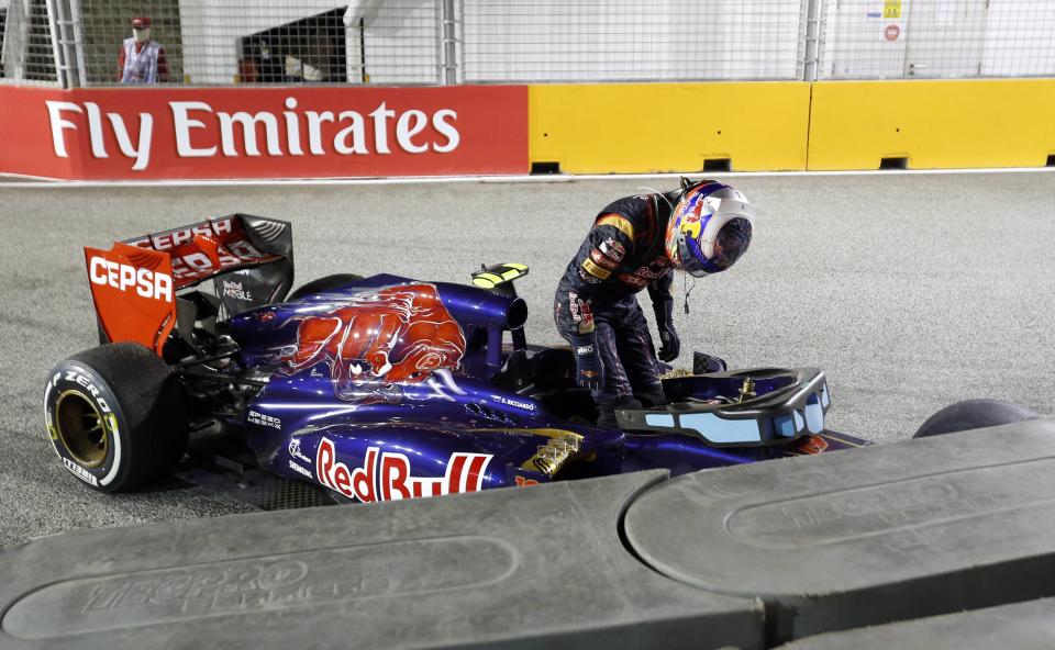 Toro Rosso Formula One driver Daniel Ricciardo of Australia gets out of his car after crashing during the Singapore F1 Grand Prix at the Marina Bay street circuit in Singapore September 22, 2013. REUTERS/Natashia Lee (SINGAPORE - Tags: SPORT MOTORSPORT F1 TPX IMAGES OF THE DAY)