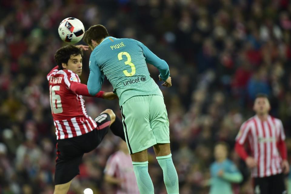 FC Barcelona's Gerard Pique, right, heads the ball beside Athletic Bilbao's Xabier Etxeita during the Spanish Copa del Rey, 16 round, first leg soccer match, between FC Barcelona and Athletic Bilbao, at San Mames stadium, in Bilbao, northern Spain, Thursday, Jan. 5, 2017. (AP Photo/Alvaro Barrientos)