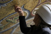 Restorer Chiara Zizola checks the consistency of the mosaics that adorn the dome of one of the oldest churches in Florence, St. John's Baptistery, in Florence, central Italy, during its restoration works, Tuesday Feb. 7, 2023. The restoration work will be done from an innovative scaffolding shaped like a giant mushroom that will stand for the next six years in the center of the church, and that will be open to visitors allowing them for the first and perhaps only time, to come come face to face with more than 1,000 square meters of precious mosaics covering the dome. (AP Photo/Andrew Medichini)