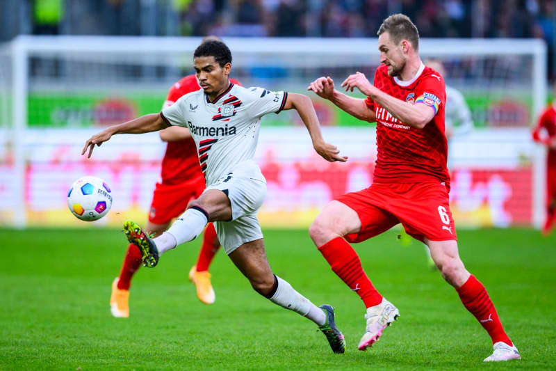 Leverkusen's Amine Adli (L) in action against Heidenheim's Patrick Mainka during the German Bundesliga soccer match between 1. FC Heidenheim and Bayer Leverkusen at the Voith-Arena. Tom Weller/dpa