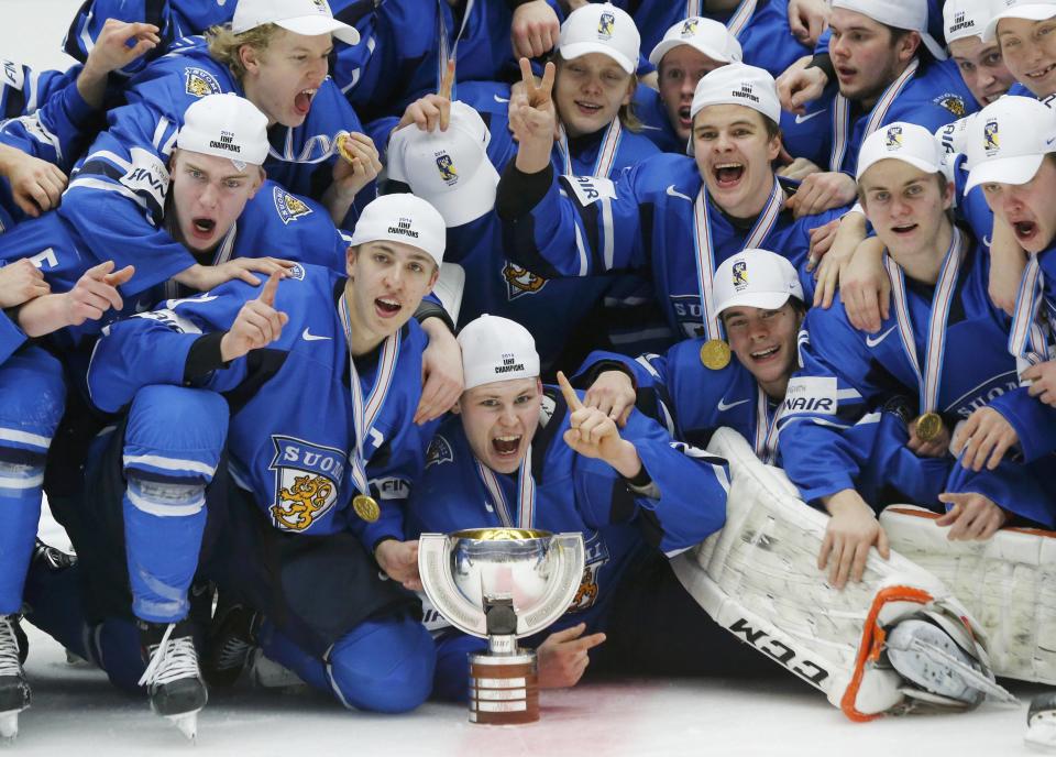 Finland players celebrate with the trophy after they defeated Sweden in overtime of their IIHF World Junior Championship gold medal ice hockey game in Malmo, Sweden, January 5, 2014. REUTERS/Alexander Demianchuk (SWEDEN - Tags: SPORT ICE HOCKEY)