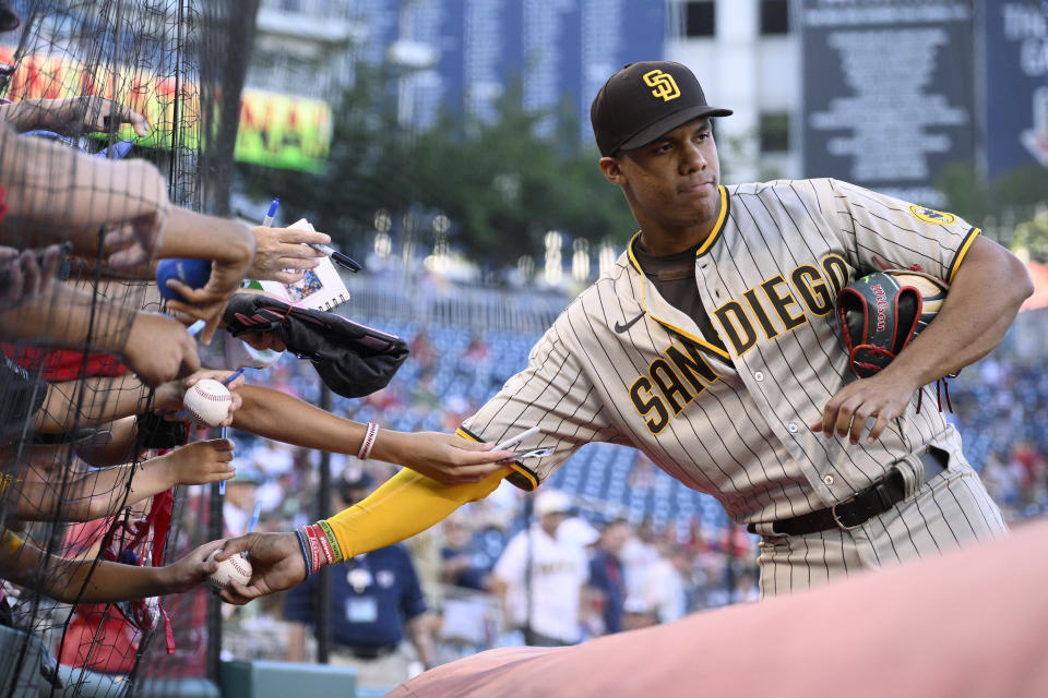 Juan Soto de los Padres de San Diego firma objetos previo a un juego contra los Nacionales de Washington, el 12 de agosto de 2022, en Washington. (AP Foto/Nick Wass)