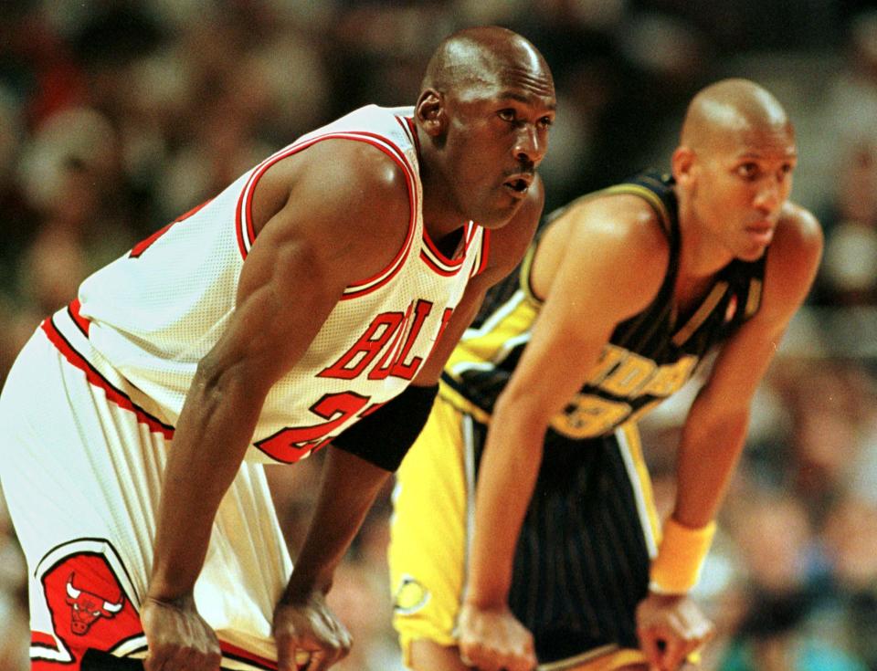 Chicago Bulls' guard Michael Jordan (L) and Indiana Pacers' guard Reggie Miller (R) rest and watch a free throw, during the first quarter of game seven of the NBA Eastern Conference Finals in Chicago, May 31.    SUE/VM/CLH/