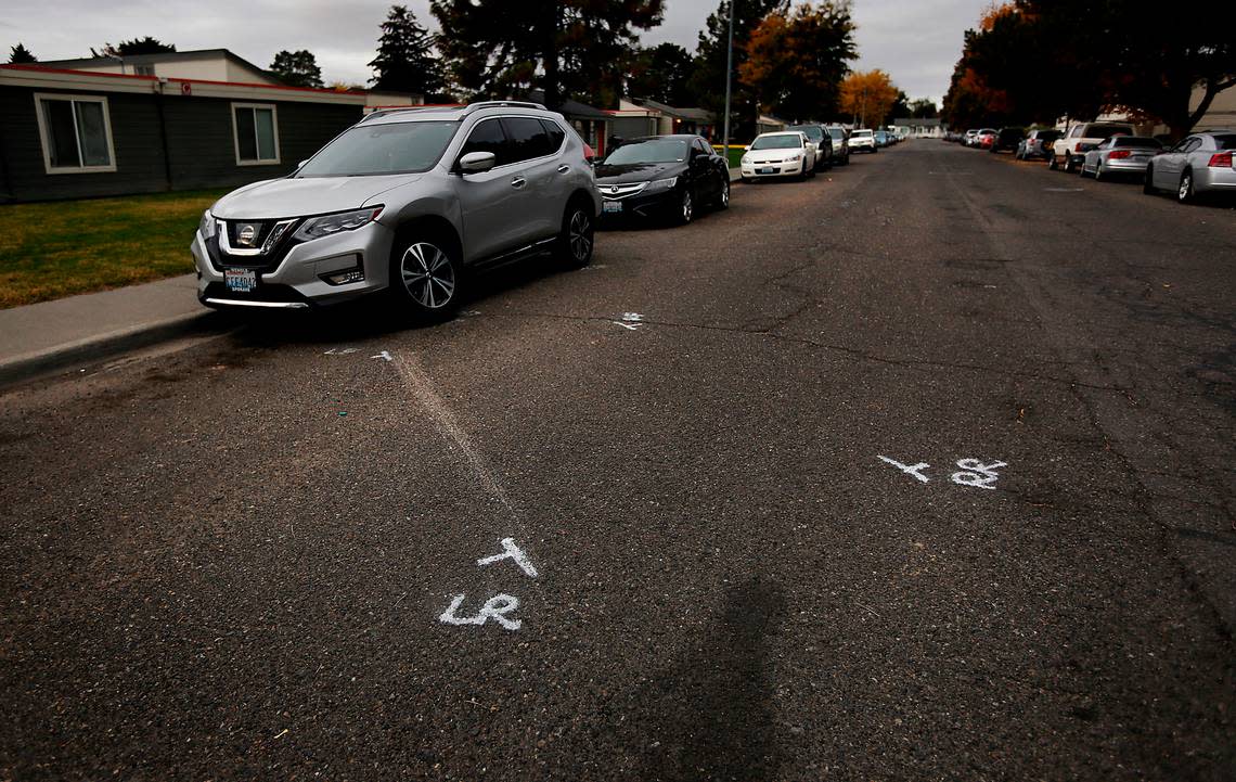 Police paint marks in the 1300 block of West Fifth Avenue in Kennewick show where the vehicle driven by Julian Chavez, 19, crashed Saturday night into a parked car. Responding police officers found Chavez in the car with a fatal gunshot wound.