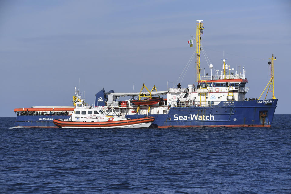 A coastguard boat approaches the German humanitarian group's rescue boat Sea Watch 3, to deliver food and blankets for the cold, off the coast of Syracuse, Italy, Sunday, Jan. 27, 2019. The Italian coast guard is bringing socks, shoes, bread and fruit to 47 migrants who have been stranded at sea for nine days aboard a German ship. (AP Photo/Salvatore Cavalli)