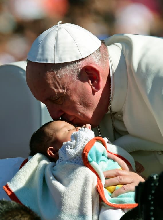 Pope Francis kisses a baby from the popemobile upon arrival in San Cristobal de las Casas in Chiapas State for his second open-air mass, on February 15, 2016