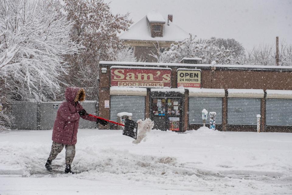 PHOTO: A person clears snow from a driveway in Lawrence, Massachusetts on January 7, 2024. (Joseph Prezioso/AFP via Getty Images)