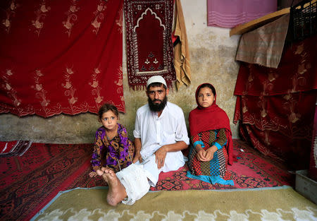 Mehrullah Safi 28, disable Afghan National Army (ANA) soldier sits with his children at their house in Jalalabad province, Afghanistan. August 2, 2017. REUTERS/Parwiz