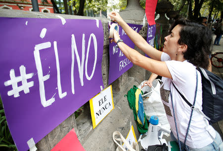 A Brazilian living in Mexico place signs during a demonstration against Brazil's presidential candidate Jair Bolsonaro ahead of the country's elections, at the Angel of Independence monument in Mexico City, Mexico September 29, 2018. REUTERS/Gustavo Graf