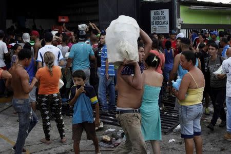 People carry goods taken from a food wholesaler after it was broken into, in La Fria, Venezuela December 17, 2016. REUTERS/Carlos Eduardo Ramirez