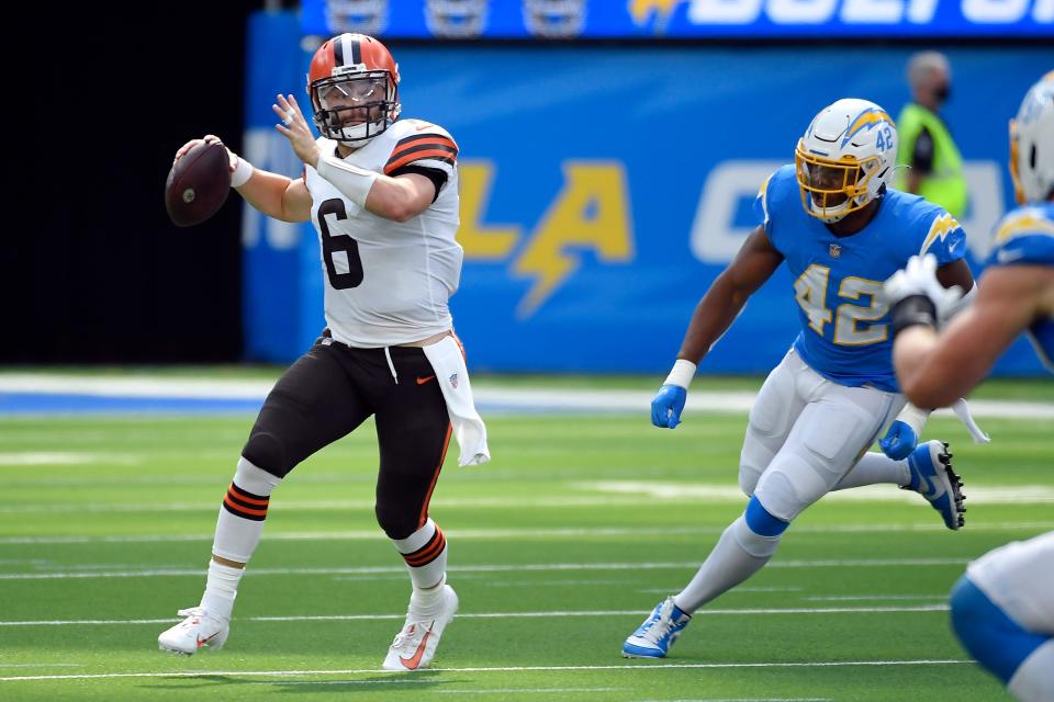 Cleveland Browns quarterback Baker Mayfield (6) looks to throw as Los Angeles Chargers outside linebacker Uchenna Nwosu (42) chases during the first half of an NFL football game Sunday, Oct. 10, 2021, in Inglewood, Calif. (AP Photo/Kevork Djansezian)