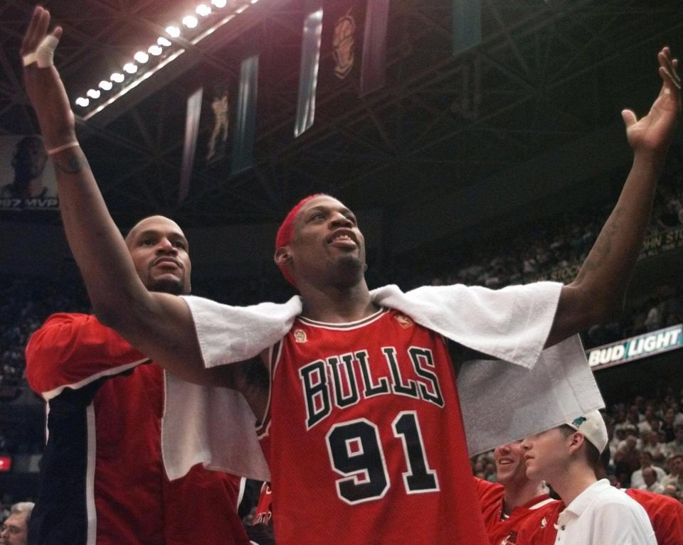 The Chicago Bulls' Dennis Rodman gestures to the crowd in front of Ron Harper at the end of Game 5 of the NBA Finals with the Utah Jazz on Wednesday, June 11, 1997, in Salt Lake City. The Bulls beat the Jazz 90-88 to take a 3-2 lead in the series as the teams head back to Chicago for Game 6 on Friday. (AP Photo/Jack Smith)