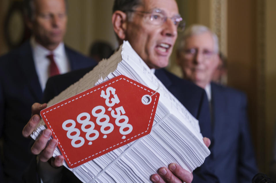 Sen. John Barrasso, R-Wyo., center, flanked by Senate Minority Whip John Thune, R-S.D., left, and Senate Minority Leader Mitch McConnell, R-Ky., right, hoists a copy of the Democrats' $3.5 trillion "Build Back Better" package as they speak to reporters after a Republican policy meeting, at the Capitol in Washington, Tuesday, Sept. 28, 2021. (AP Photo/J. Scott Applewhite)