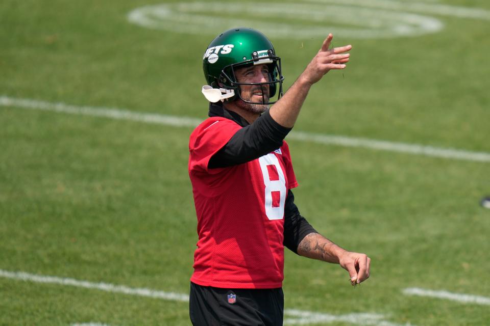 New York Jets quarterback Aaron Rodgers throws grass in the air at the NFL football team's training facility in Florham Park, N.J., Tuesday, June 6, 2023.