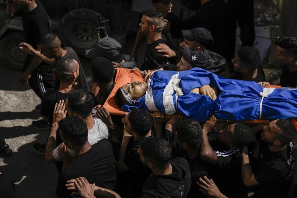 Palestinians carry the body of militant Samer El Shafei in the Nur Shams refugee camp near the city of Tulkarem, in the occupied West Bank Saturday, May 6, 2023 , Saturday, May 6, 2023. Palestinian Health Ministry says Israeli forces have shot dead two Palestinians during a military raid in the occupied West Bank, while a local armed group said the pair were militants. Saturday's deadly raid in the Nur Shams refugee camp near the city of Tulkarem was the latest in Israeli-Palestinian violence that has all but surged since last year. Palestinians said the two dead were 22 years and are members of a local armed group. (AP Photo/Majdi Mohammed)