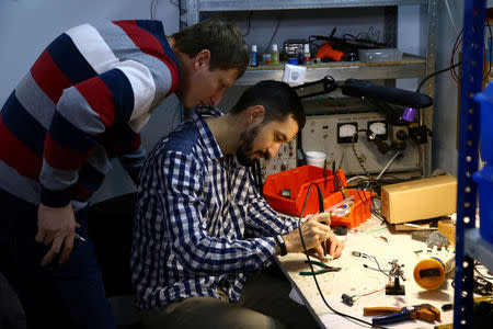 Oleg Galtsev, software engineer, (R) with his colleague design engineer Sergey Arefyev, work at their workshop on a prosthetic right hand for Oleg's father, in Minsk, Belarus October 16, 2016. REUTERS/Vasily Fedosenko