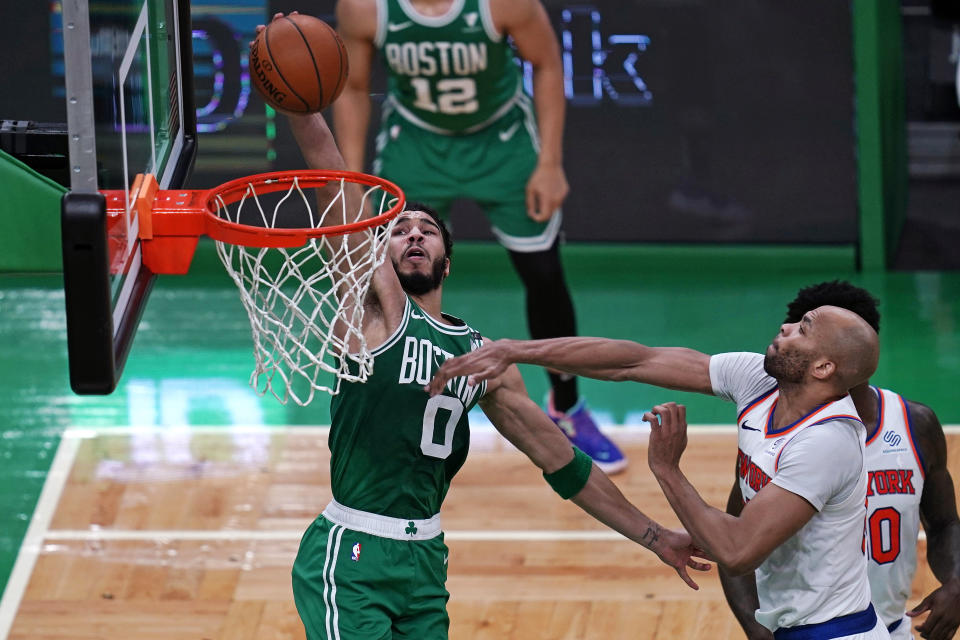 Boston Celtics forward Jayson Tatum (0) dunks after driving past New York Knicks center Taj Gibson, right, during the first half of an NBA basketball game Wednesday, April 7, 2021, in Boston. (AP Photo/Charles Krupa)