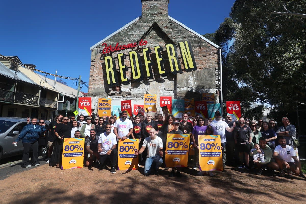 Yes23 supporters hold placards as they gather for a photo during an event at the Redfern Community Centre (Getty)