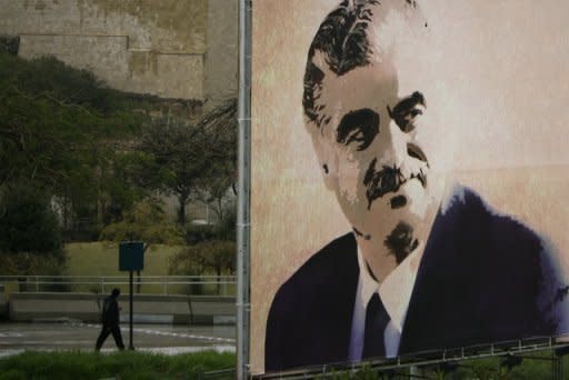 A Lebanese man walks past a billboard that shows a picture of assassinated Lebanese prime minister Rafiq Hariri in downtown Beirut. Lebanon braced for a possible backlash after a UN-backed tribunal issued an indictment in the 2005 murder of ex-premier Rafiq Hariri in which four Hezbollah members are named