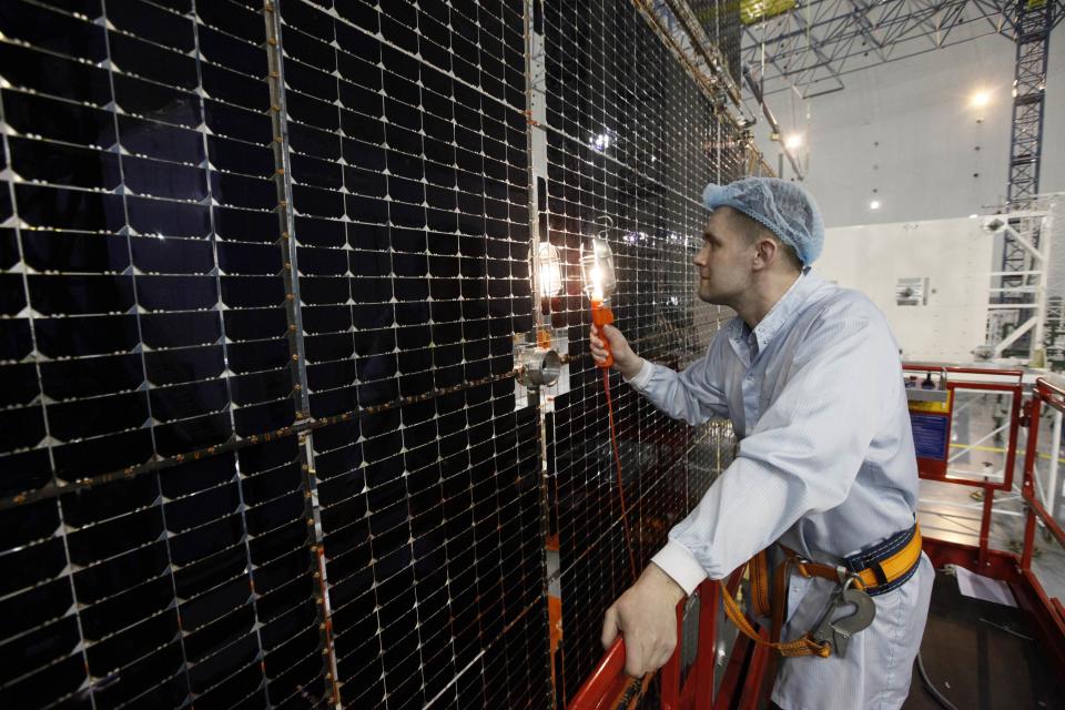 Andrei Khrustov, chief engineer of the "Kvant" (Quantum) research-and-production enterprise, inspects a solar battery for the Express AM6 new generation geostationary telecommunications heavy satellite of the Reshetnev Information Satellite Systems company in the Siberian town of Zheleznogorsk April 2, 2014. The Express AM6 is a new generation satellite providing services including Russian governmental and presidential mobile communication, digital television and broadcasting, according to the Reshetnev company representatives. Picture taken April 2, 2014. REUTERS/Ilya Naymushin (RUSSIA - Tags: SCIENCE TECHNOLOGY BUSINESS ENERGY)