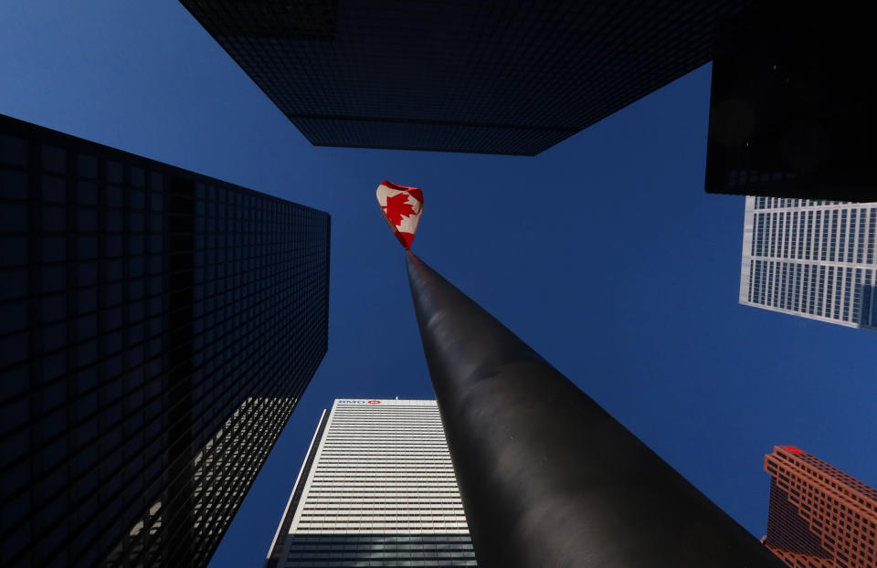 A Canadian flag flies in the financial district between the towers of the Toronto-Dominion Center, the Bank of Montreal building, the Canadian Imperial Bank of Commerce headquarters and Bank of Nova Scotia tower in Toronto, Canada. (Photo by Gary Hershorn/Getty Images)