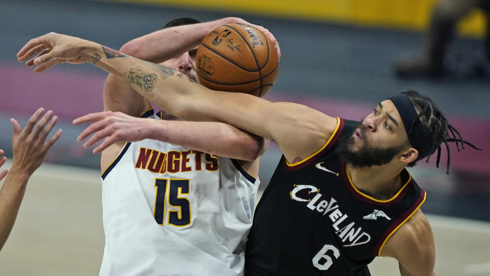 Cleveland Cavaliers' JaVale McGee (6) and Denver Nuggets' Nikola Jokic (15) vie for a rebound during the first half of an NBA basketball game Friday, Feb. 19, 2021, in Cleveland. (AP Photo/Tony Dejak)