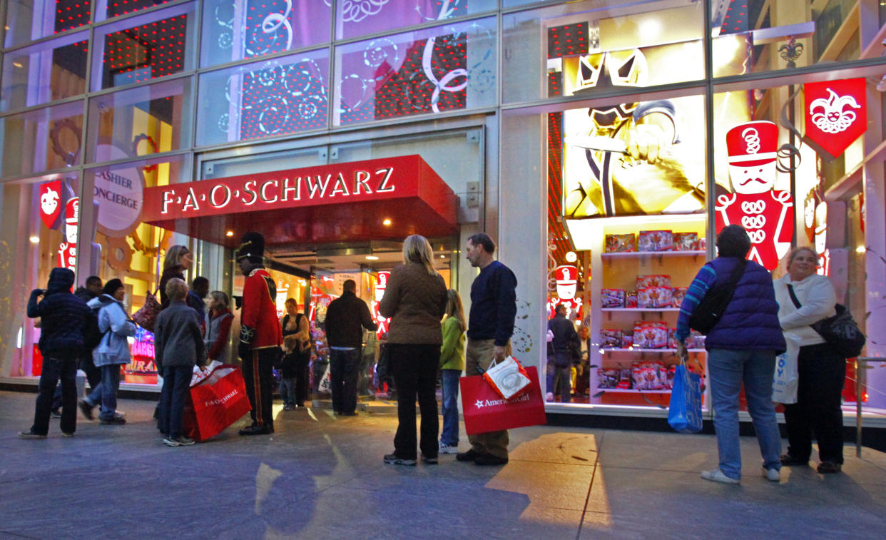 FILE - In this Nov. 21, 2011, file photo, shoppers stand outside of FAO Schwarz in New York. Toys R Us is closing its iconic FAO Schwarz store, citing the high and rising costs of running the retail space on New York City's pricey Fifth Avenue, the company said Friday, May 15, 2015. (AP Photo/Bebeto Matthews, File)