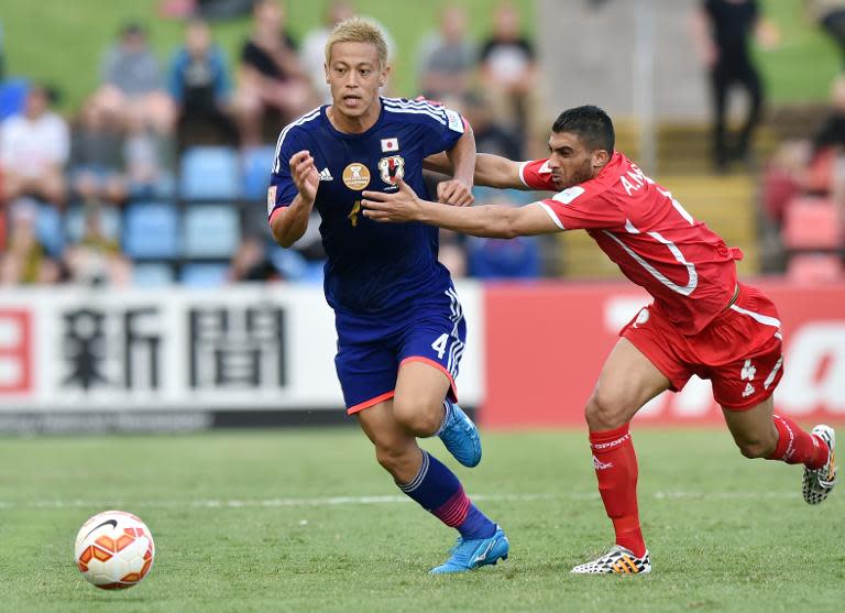 Keisuke Honda of Japan (L) is fouled by Ahmed Mahajna of Palestine (R) during their Group D football match of the AFC Asian Cup in Newcastle, January 12, 2015