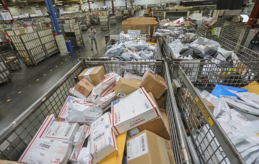 Postal workers sort parcels at Margaret L. Sellers Processing and Distribution Center at the USPS Carmel Mountain Post Office on May 14, 2020 in San Diego, California. The post office is seeing a huge increase in the amount of packages its handling.