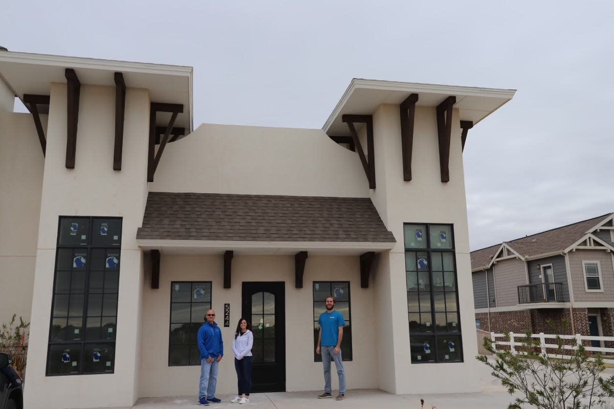 People stand outside the upcoming Fyzical Therapy and Balance Centers Lubbock South-West, 5244 114th St., which will open on Dec.18, 2023.