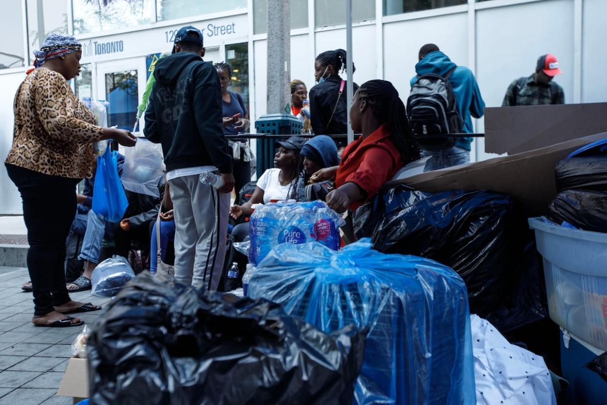 Refugee claimants and asylum seekers slept on the street in front of a Toronto shelter intake office for weeks last summer, after the city said it could no longer cope with the high number of claimants hoping to access a bed (Alex Lupul/CBC - image credit)