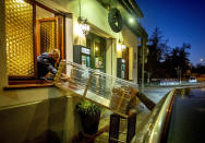 FILE - -In this Thursday, Nov.5, 2020 file photo, a box with food slides down to car from a window of the apple cider restaurant 'Zum Lahmen Esel' in Frankfurt, Germany. Due to the new partial lockdown to avoid the coronavirus spread the restaurant which has been in operation since 1807 offers cider and food to go in a self-made drive through set up. Germany is set to mark 100,000 deaths from COVID-19 this week, passing a somber milestone that several of its neighbors crossed months ago but which some in Western Europe's most populous nation had hoped to avoid. (AP Photo/Michael Probst, file)
