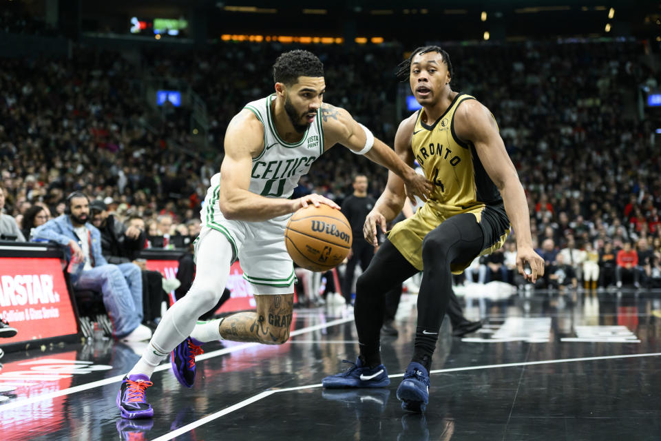 Boston Celtics forward Jayson Tatum (0) drives around Toronto Raptors forward Scottie Barnes (4) during the second half of an NBA basketball game in Toronto on Friday, Nov. 17, 2023. (Christopher Katsarov/The Canadian Press via AP)