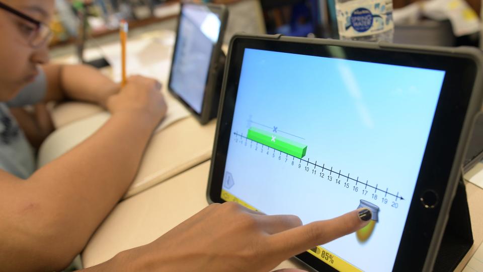 Sixth-grade students in Worcester use tablets to solve a practice MCAS math problem.