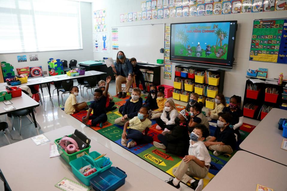 Students gather around kindergarten teacher Carolyn Pietkewicz for story time at New Hampstead K-8.