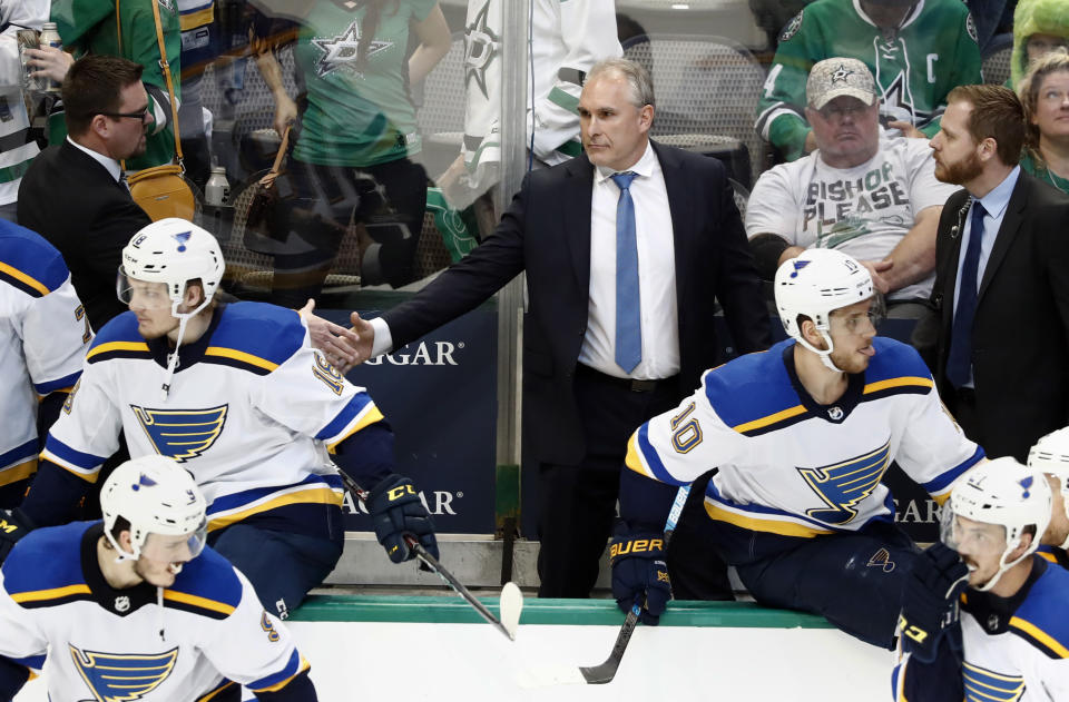 St. Louis Blues interim head coach Craig Berube, center, shakes hands with staff, celebrating the team's 4-1 win against the Dallas Stars in Game 6 of an NHL second-round hockey playoff series in Dallas, Sunday, May 5, 2019. (AP Photo/Tony Gutierrez)