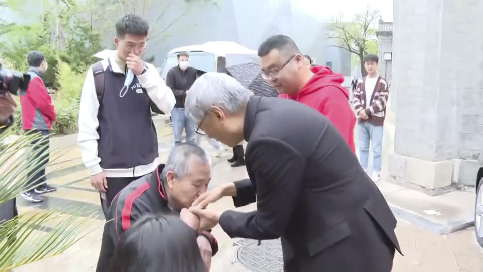 In this image taken from video footage run by TVB, Hong Kong Bishop Stephen Chow meets with a member of the faithful outside Wangfujing Church in Beijing, Friday, April 21, 2023. Hong Kong's Roman Catholic bishop on Friday said he had invited a leader of the Communist Party-controlled group for Catholics in mainland China to visit his city, in a high-profile gesture aimed at improving strained Vatican relations with Beijing. (TVB via AP)