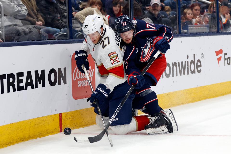 Florida Panthers forward Eetu Luostarinen, left, and Columbus Blue Jackets defenseman Nick Blankenburg work for the puck during the first period of an NHL hockey game in Columbus, Ohio, Sunday, Dec. 10, 2023. (AP Photo/Paul Vernon)