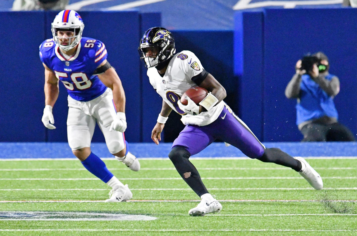 Jan 16, 2021; Orchard Park, New York, USA; Baltimore Ravens quarterback Lamar Jackson (8) runs with the ball against the Buffalo Bills during the first half of an AFC Divisional Round playoff game at Bills Stadium. Mandatory Credit: Mark Konezny-USA TODAY Sports