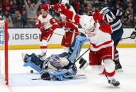 Detroit Red Wings forward Dylan Larkin, right, celebrates his goal against Columbus Blue Jackets goalie Elvis Merzlikins, front left, during the first period of an NHL hockey game in Columbus, Ohio, Monday, Nov. 15, 2021. (AP Photo/Paul Vernon)