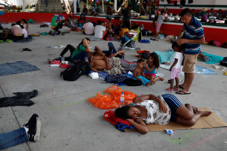 Eight months pregnant Honduran migrant Erly Marcial, 21, lies on cardboard while she stays with her family and fellow migrants in Tapanatepec, Mexico, November 6, 2018. REUTERS/Carlos Garcia Rawlins