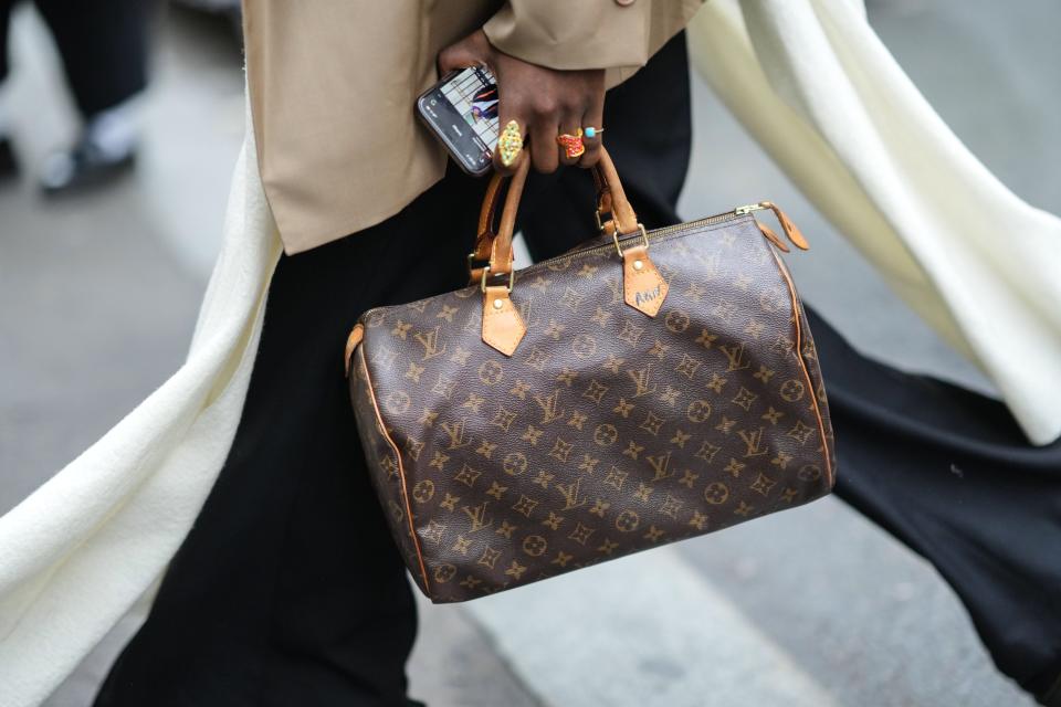 a woman carries a Louis Vuitton bag