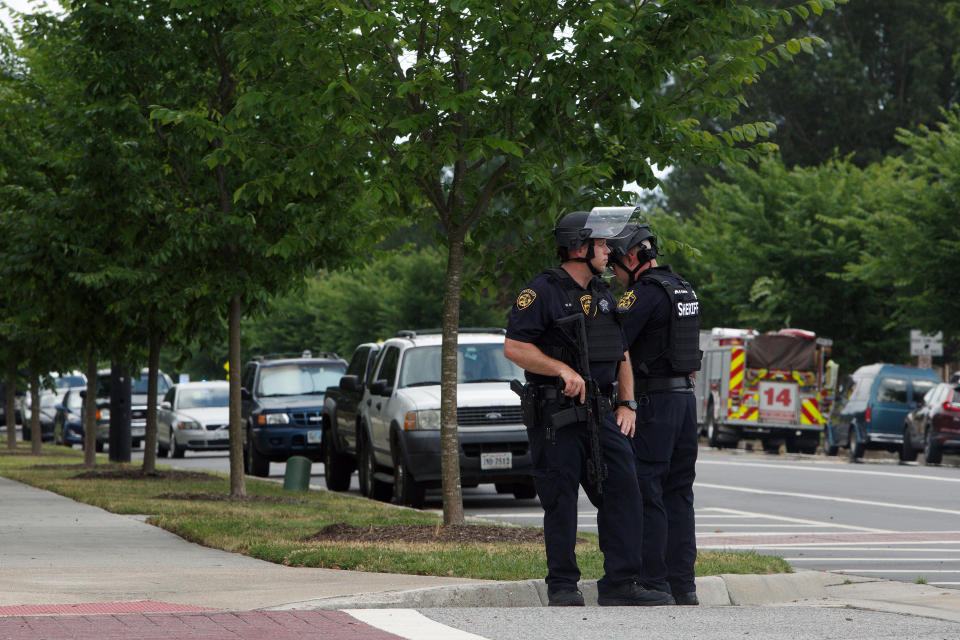 FILE - Virginia Beach Police Officers huddle near the intersection of Princess Anne Road and Nimmo Parkway following a shooting at the Virginia Beach Municipal Center on Friday, May 31, 2019 in Virginia Beach, Va. A state commission tasked with investigating the 2019 mass shooting in Virginia Beach has called for numerous changes to how Virginia and its communities respond to mass shootings. (Kaitlin McKeown/The Virginian-Pilot via AP, File Photo