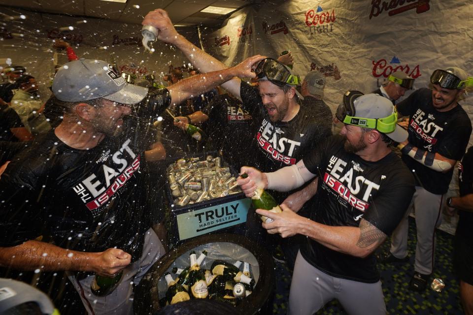 Atlanta Braves players celebrate in the club house after they clinched their fifth consecutive NL East title by defeating the Miami Marlins 2-1, in a baseball game, Tuesday, Oct. 4, 2022, in Miami. (AP Photo/Wilfredo Lee)