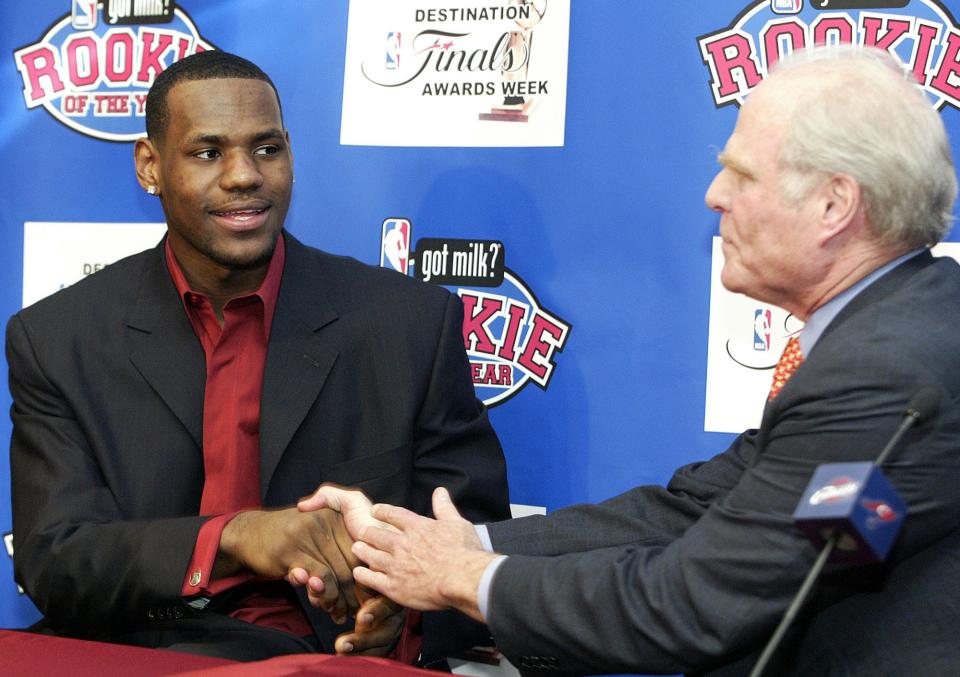 Cavaliers star LeBron James, left, receives congratulations from team owner Gordon Gund, right, as James is announced as the NBA Rookie of the Year during a news conference on April 20, 2004.