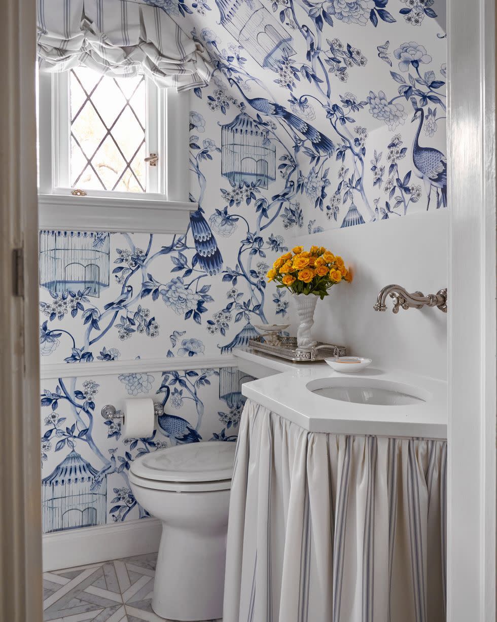 a bathroom with a sink toilet and a flower vase