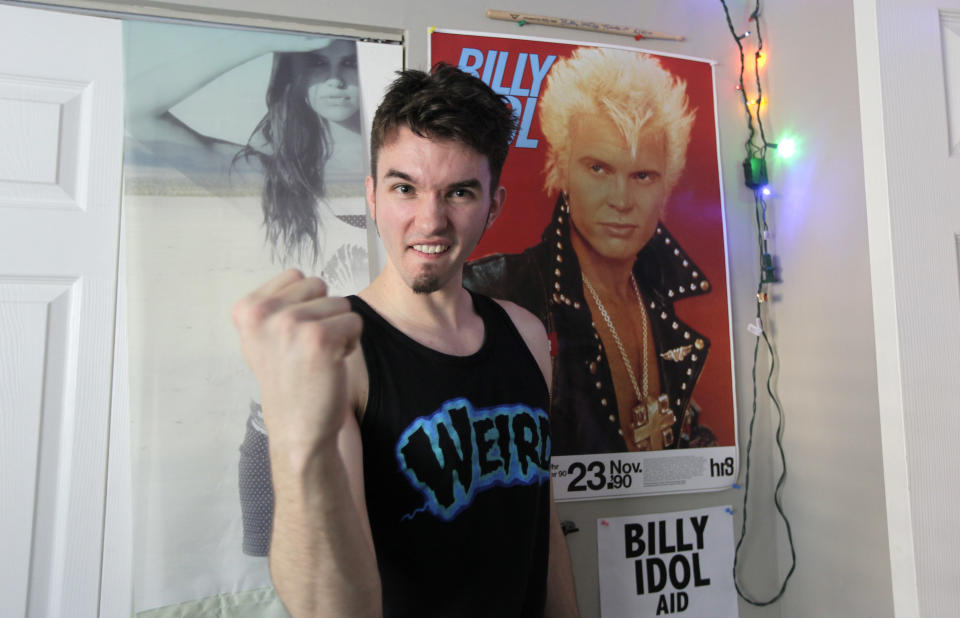 Michael Henrichsen poses for a photo, Sept. 19, 2012 in his bedroom at his home in Seattle next to a poster of rock star Billy Idol. Henrichsen created a website and enlisted friends and celebrities around the world in a two-year effort to convince Idol to come play a concert on Oct. 26, 2012 at a Seattle music venue to raise money for charity and celebrate Henrichsen's birthday. (AP Photo/Ted S. Warren)