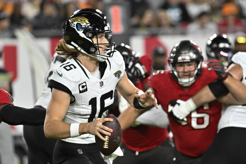 Jacksonville Jaguars quarterback Trevor Lawrence (16) looks for a receiver as he scrambles from the pocket during the second half of an NFL football game against the Tampa Bay Buccaneers Sunday, Dec. 24, 2023, in Tampa, Fla. (AP Photo/Jason Behnken)